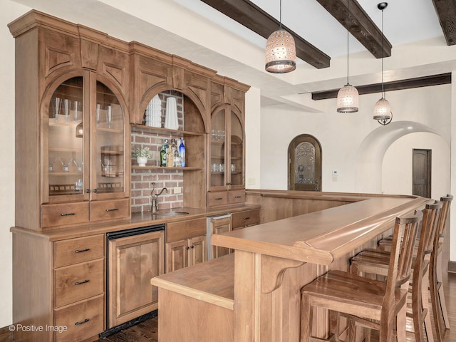 bar featuring sink, decorative light fixtures, and beam ceiling