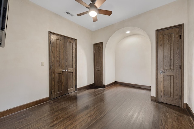 unfurnished bedroom featuring dark wood-type flooring and ceiling fan