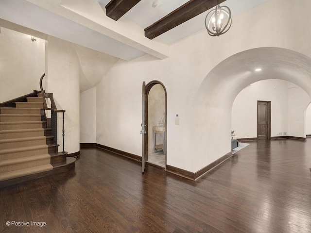 interior space with a notable chandelier, beamed ceiling, and dark hardwood / wood-style flooring