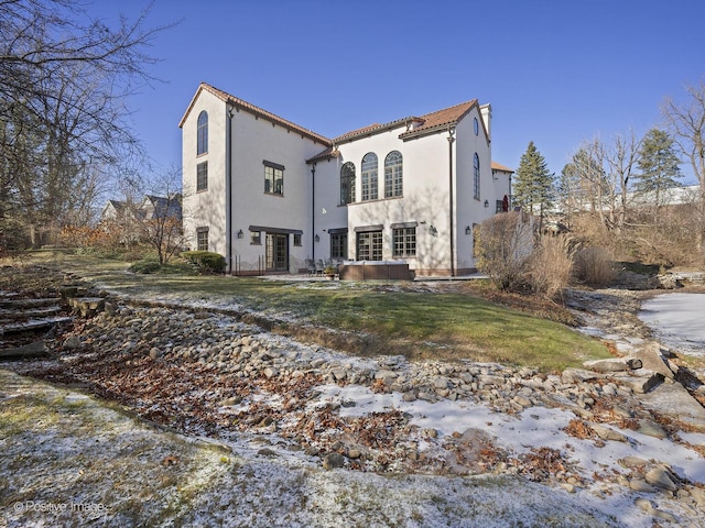 rear view of house featuring french doors and a lawn