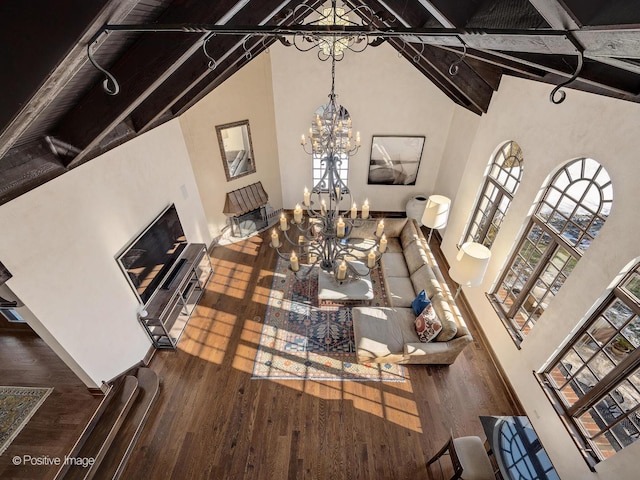 living room featuring a healthy amount of sunlight, hardwood / wood-style flooring, and beamed ceiling