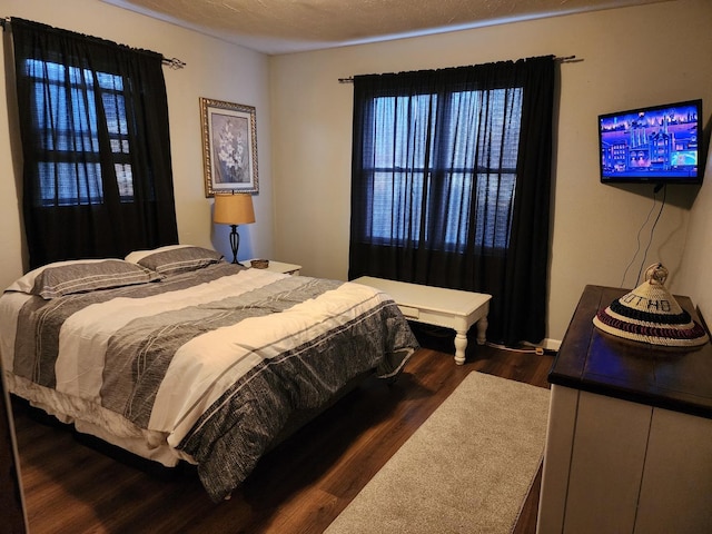 bedroom with dark wood-type flooring and a textured ceiling