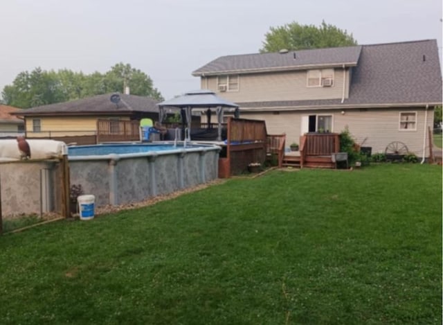 back of house with a pool side deck, a gazebo, and a lawn