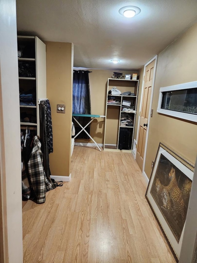 hall featuring light hardwood / wood-style flooring and a textured ceiling