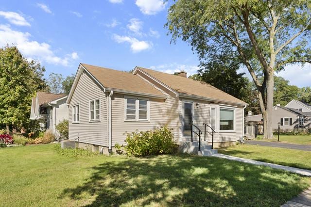 view of front of home featuring cooling unit and a front yard