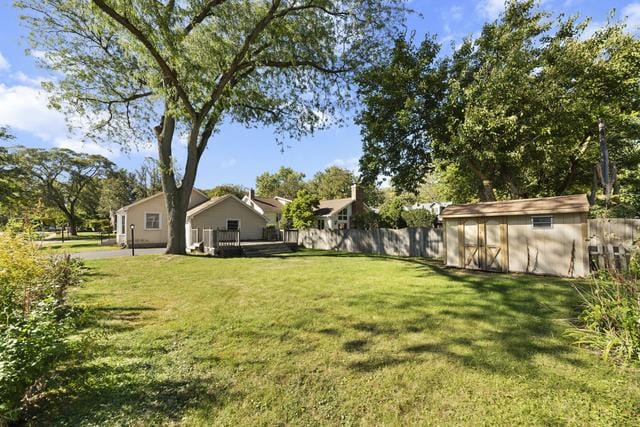 view of yard featuring a wooden deck and a storage shed