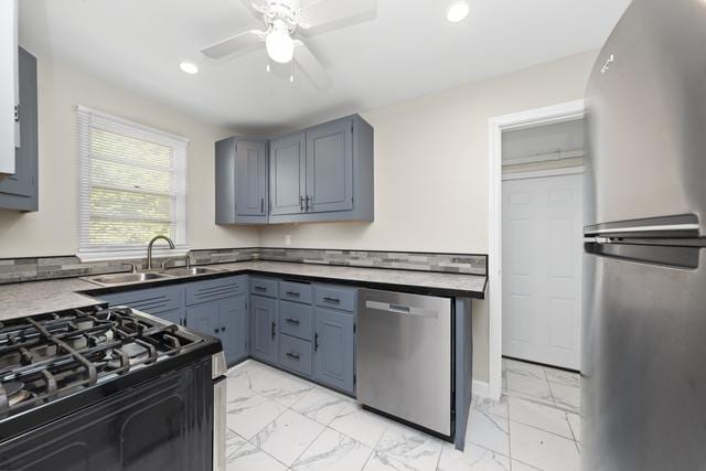 kitchen with appliances with stainless steel finishes, ceiling fan, and sink