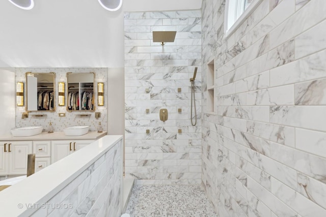 bathroom featuring vanity, tiled shower, and tasteful backsplash