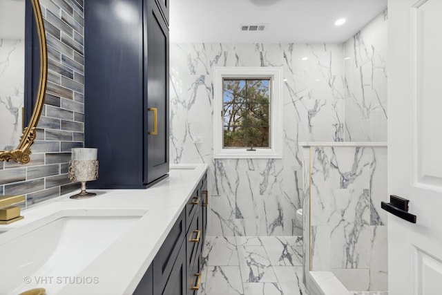 bathroom featuring a shower, vanity, and tile walls