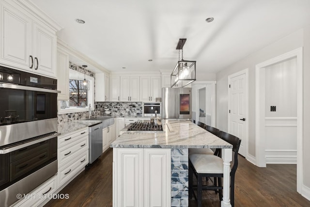 kitchen with dark hardwood / wood-style flooring, a center island, stainless steel appliances, and decorative light fixtures