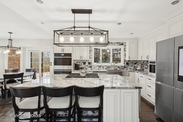 kitchen with sink, white cabinets, a spacious island, and appliances with stainless steel finishes