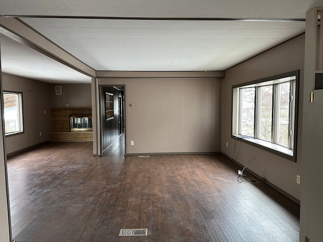 empty room featuring dark wood-type flooring and wood walls