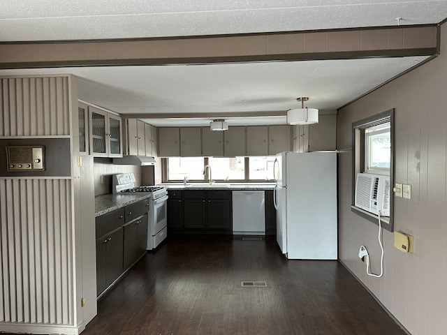 kitchen with white appliances, exhaust hood, sink, dark hardwood / wood-style floors, and light stone counters