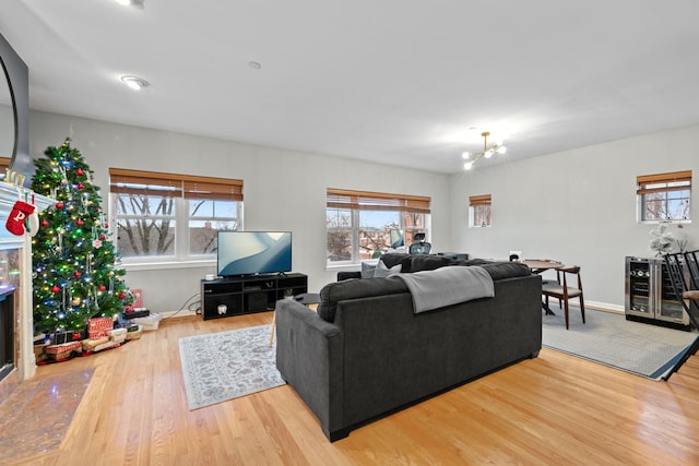 living room with hardwood / wood-style flooring, an inviting chandelier, and beverage cooler