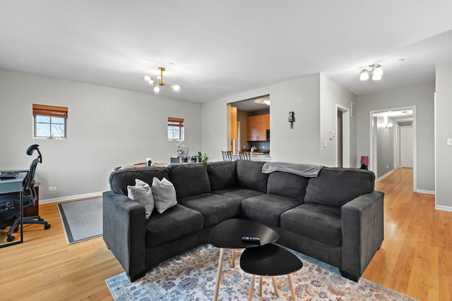 living room with light hardwood / wood-style flooring and a notable chandelier