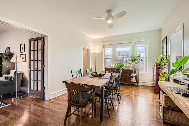 dining room with ceiling fan and dark hardwood / wood-style flooring