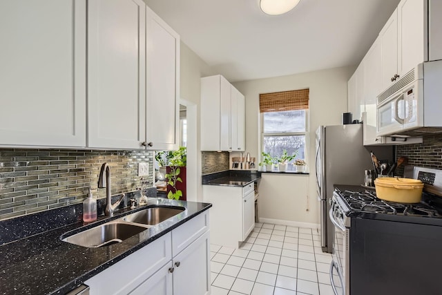 kitchen featuring sink, stainless steel range with gas stovetop, white cabinets, and light tile patterned floors