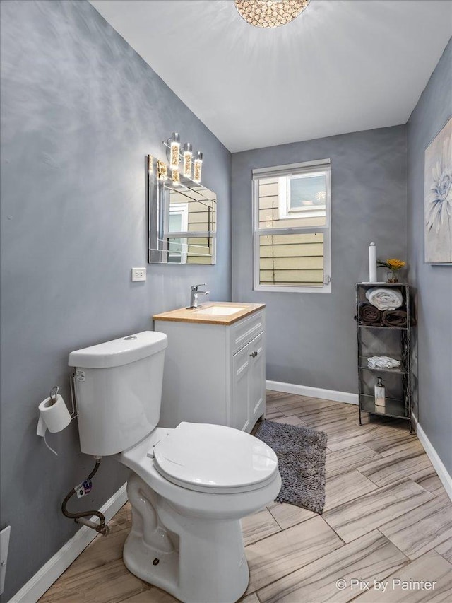 bathroom with vanity, wood-type flooring, and toilet