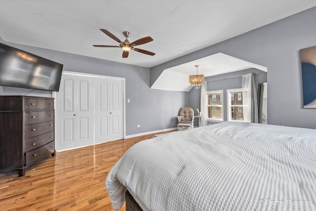 bedroom with ceiling fan, light hardwood / wood-style floors, and a closet