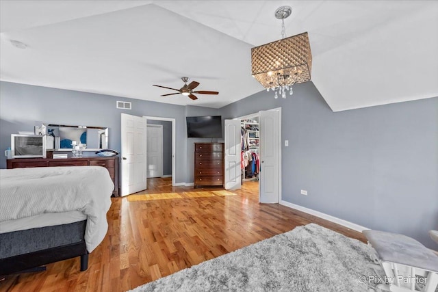 bedroom featuring a spacious closet, ceiling fan, light hardwood / wood-style floors, and lofted ceiling