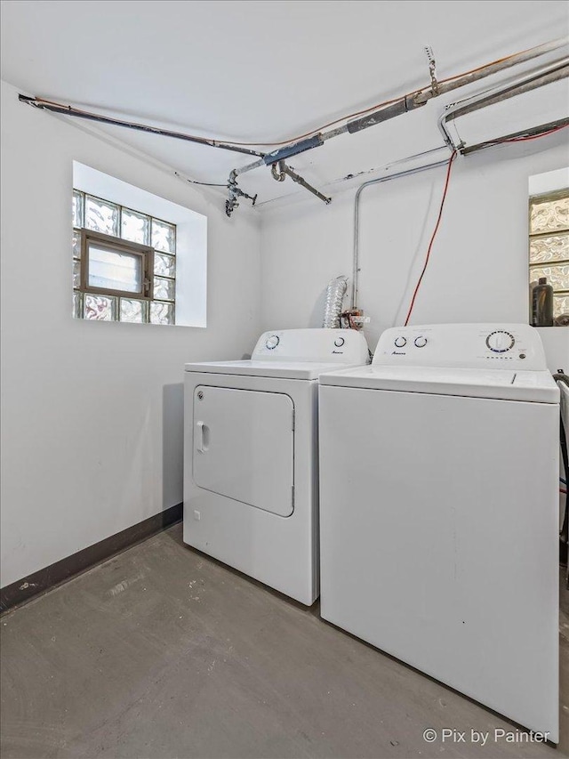 clothes washing area with independent washer and dryer and a healthy amount of sunlight