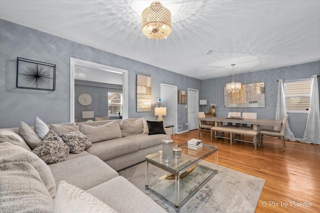 living room featuring hardwood / wood-style flooring and an inviting chandelier