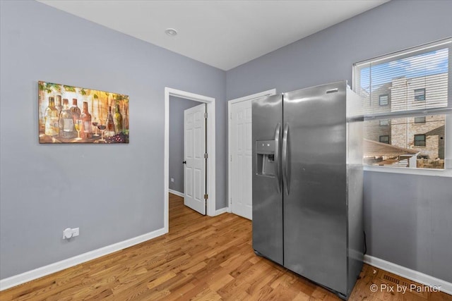 kitchen featuring hardwood / wood-style flooring and stainless steel fridge with ice dispenser