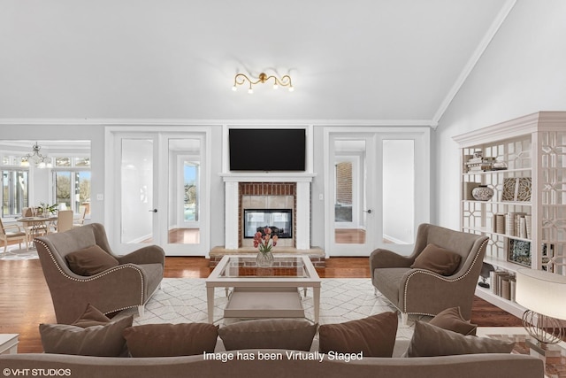 living room featuring crown molding, light hardwood / wood-style flooring, and vaulted ceiling