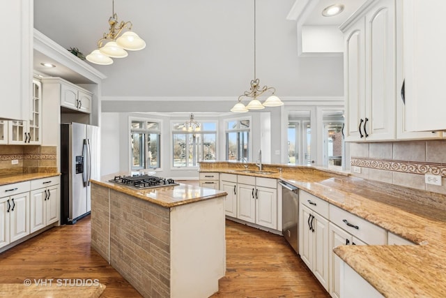 kitchen with white cabinets, light stone counters, light wood-type flooring, and appliances with stainless steel finishes