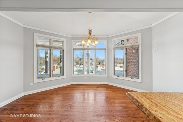 unfurnished dining area with hardwood / wood-style floors, an inviting chandelier, and ornamental molding