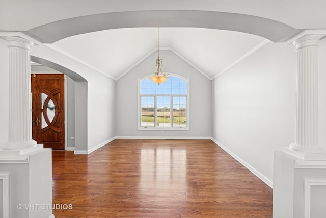 unfurnished living room with ornate columns, lofted ceiling, and hardwood / wood-style flooring