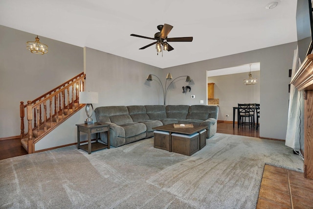 living room featuring dark hardwood / wood-style flooring and ceiling fan with notable chandelier