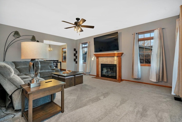 carpeted living room featuring ceiling fan and a fireplace