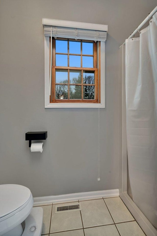 bathroom with tile patterned floors, toilet, and a shower with shower curtain