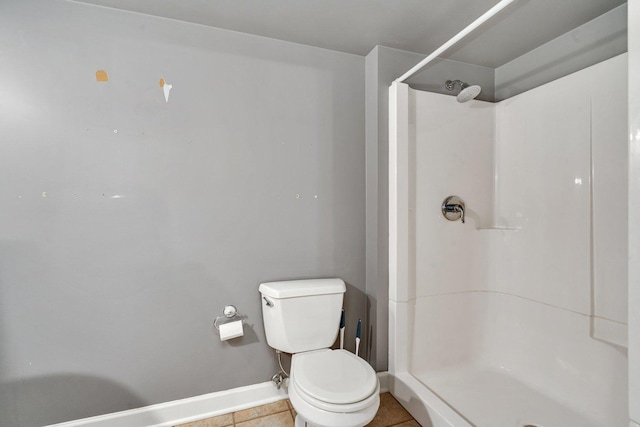 bathroom with tile patterned flooring, toilet, and walk in shower