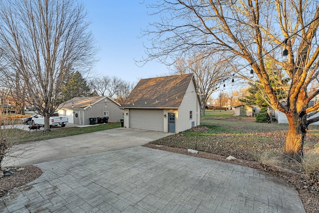 view of home's exterior with a lawn, an outdoor structure, and a garage