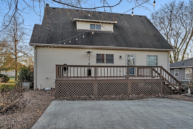 back of property featuring a wooden deck and a patio