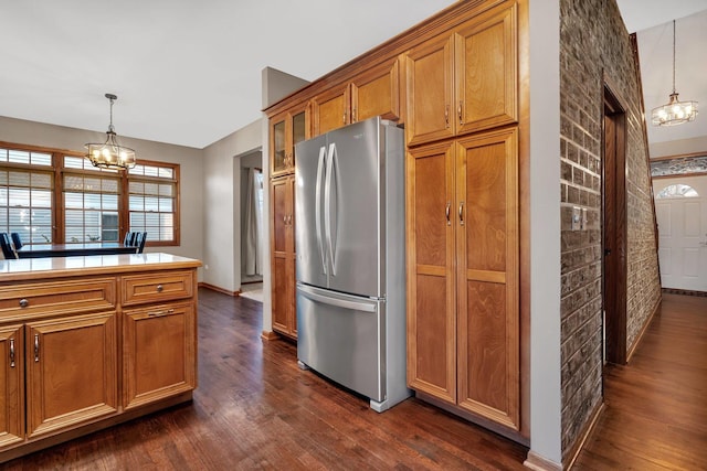 kitchen with a notable chandelier, stainless steel fridge, dark hardwood / wood-style floors, and decorative light fixtures