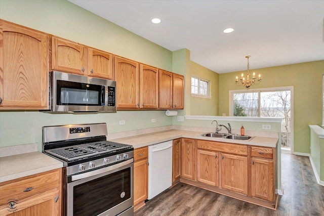 kitchen featuring sink, stainless steel appliances, an inviting chandelier, dark hardwood / wood-style flooring, and decorative light fixtures