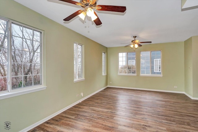 spare room featuring ceiling fan, hardwood / wood-style floors, and plenty of natural light