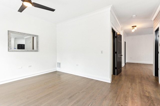 empty room featuring crown molding, ceiling fan, and dark wood-type flooring