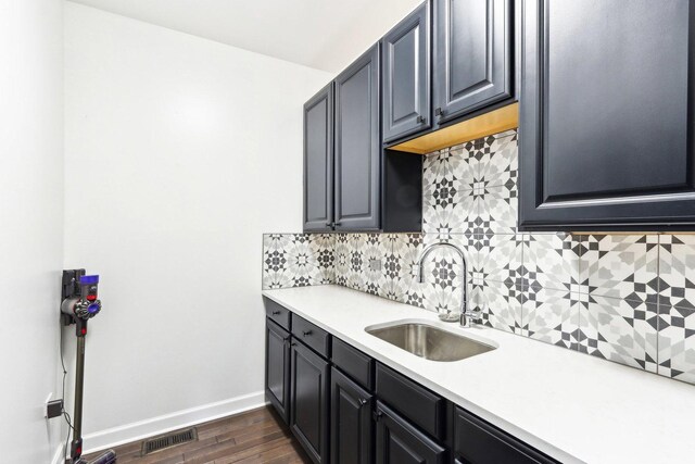 kitchen featuring decorative backsplash, sink, and dark wood-type flooring