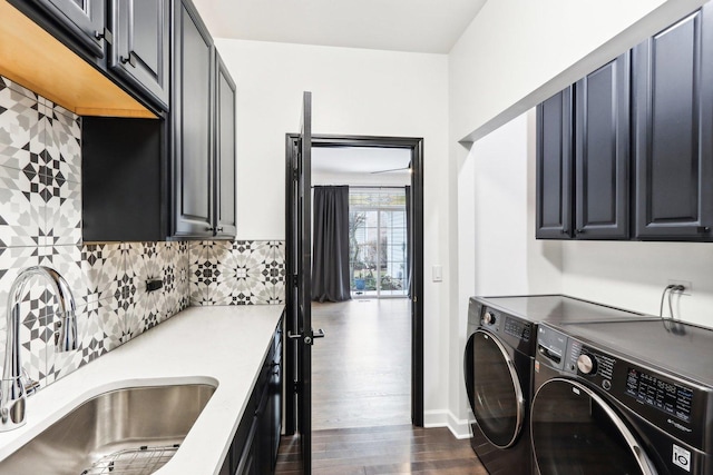 laundry area with cabinets, dark hardwood / wood-style flooring, sink, and washing machine and clothes dryer