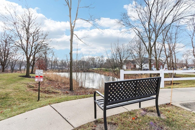 view of community with a lawn and a water view