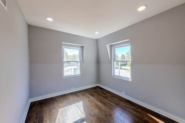 additional living space with plenty of natural light and dark hardwood / wood-style flooring