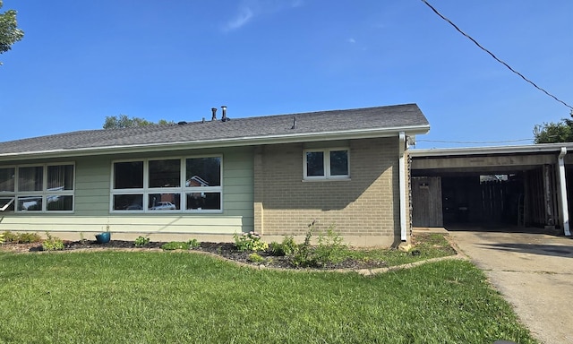 view of side of home with a carport and a lawn