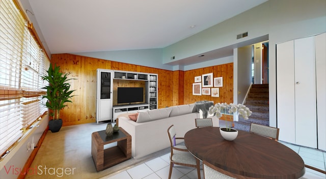 living room featuring wood walls, light tile patterned flooring, and high vaulted ceiling