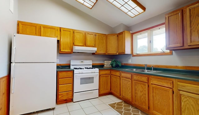 kitchen featuring lofted ceiling, white appliances, sink, and light tile patterned floors