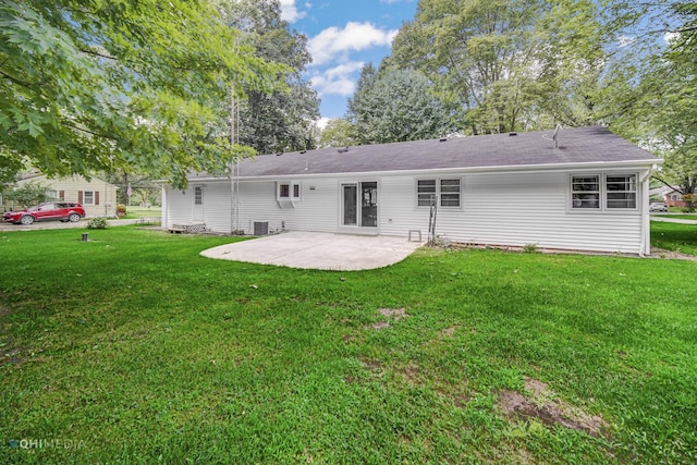 rear view of property featuring a lawn, a patio area, and central AC