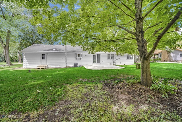 rear view of house with a lawn, a patio area, and cooling unit